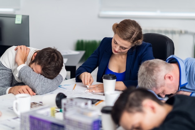 donna che lavora sodo mentre i suoi colleghi stanno avendo una pausa.