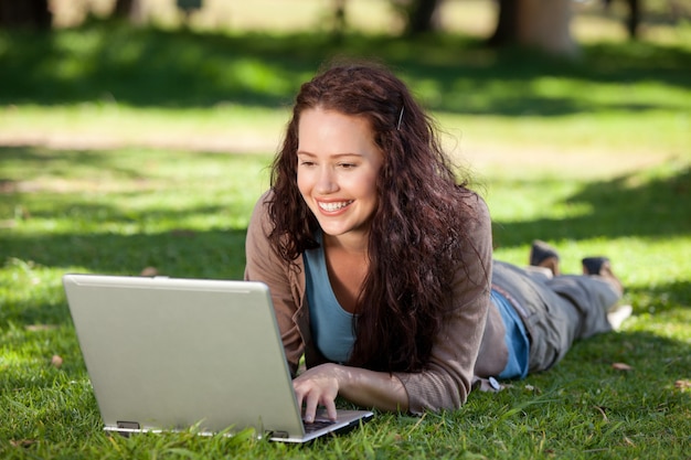 Donna che lavora sul suo computer portatile nel parco