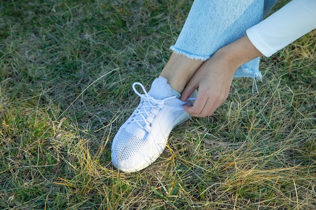 Donna che lega i lacci delle scarpe all'aperto