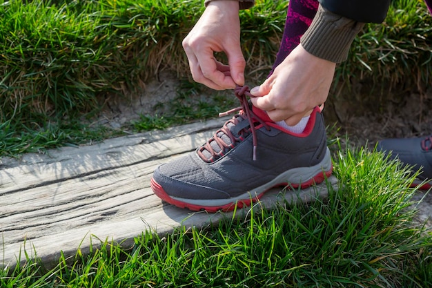 Donna che lega i lacci delle scarpe