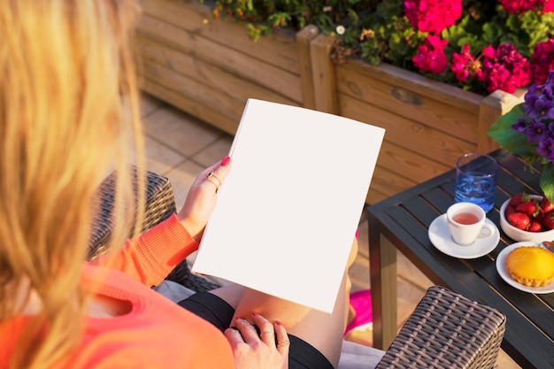 Donna che legge il modello vuoto della pagina di esempio in bianco per il tuo design