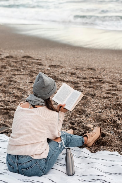 Donna che legge in spiaggia da solo