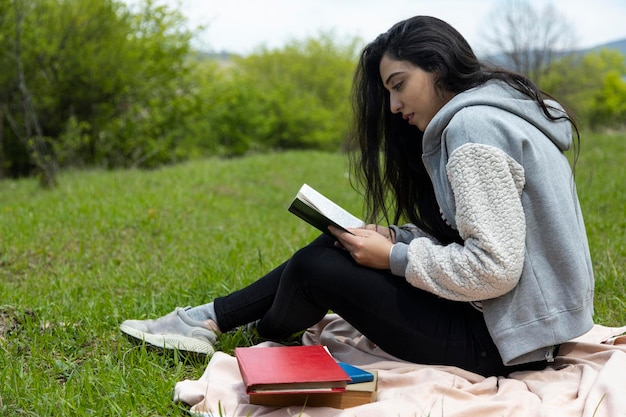 Donna che legge libri in natura