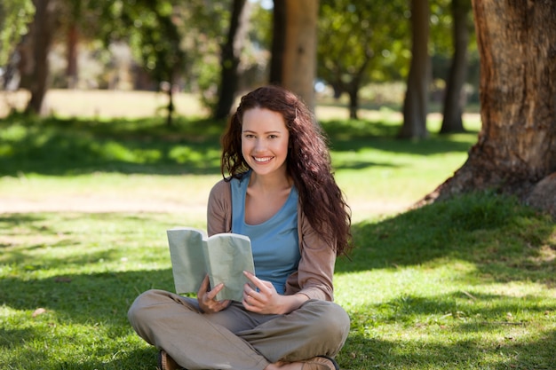 Donna che legge un libro in giardino