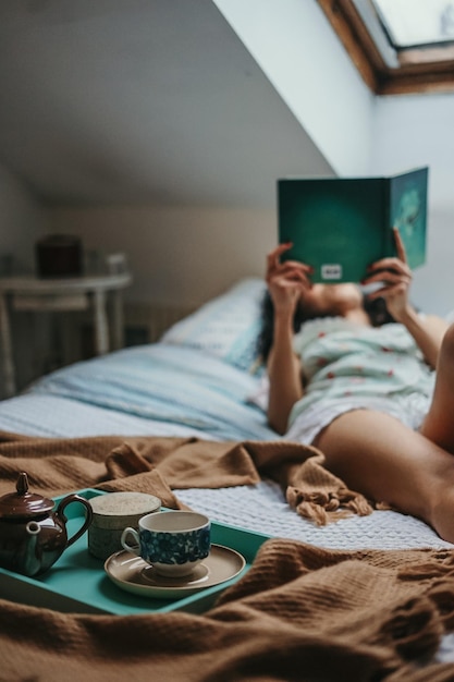 Donna che legge un libro sdraiata sul letto