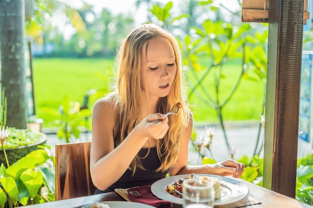 Donna che mangia cucina tradizionale balinese. Verdure e tofu saltati in padella con riso