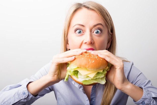 Donna che mangia hamburger