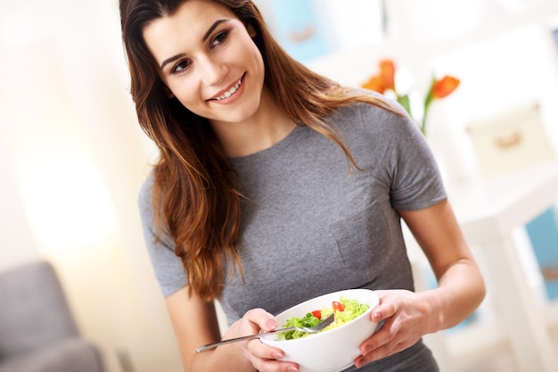 donna che mangia insalata sana a casa