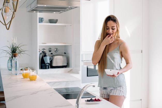 Donna che mangia prima colazione a casa