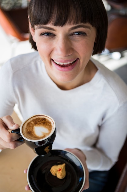 Donna che mangia tazza di caffè nel self-service