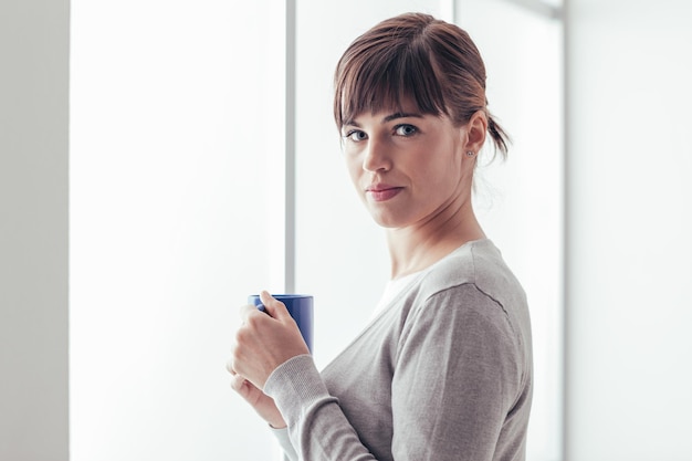 Donna che mangia un caffè caldo