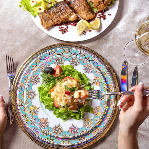 Donna che mangia una vista dall'alto di insalata di pesce