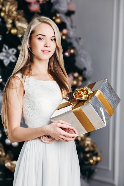 Donna che mantiene confezione regalo il giorno di Natale