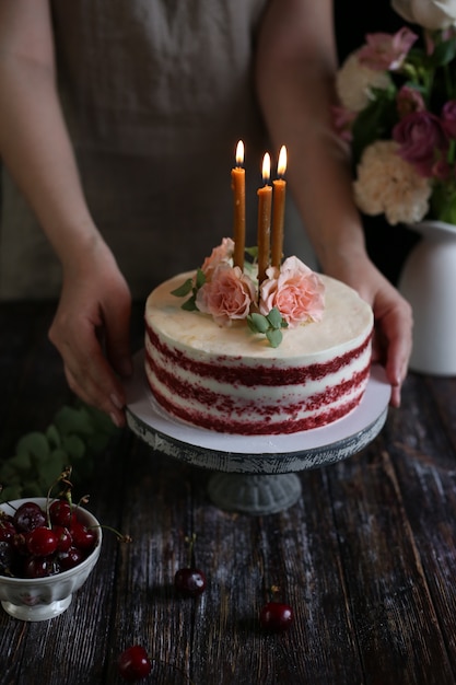 Donna che mantiene una deliziosa torta di velluto rosso