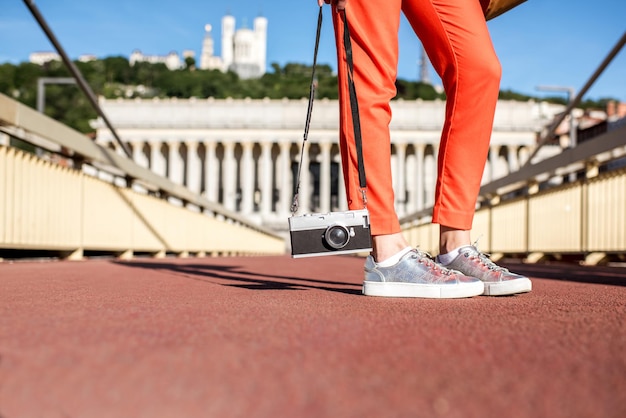 Donna che mantiene una macchina fotografica in piedi sulla passerella nella città vecchia di Lione, France