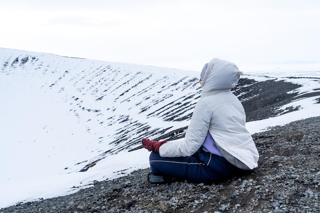 Donna che medita sul ghiacciato vulcano Hverfjall in Islanda nel freddo inverno