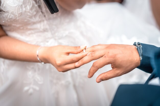 Donna che mette l'anello nuziale allo sposo alla cerimonia di matrimonio, momenti essenziali nella relazione di coppia, foto alla celebrazione del matrimonio