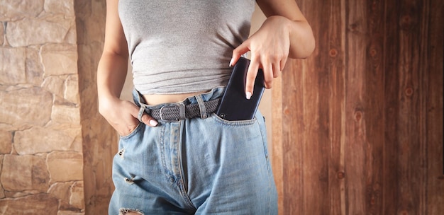 Donna che mette smartphone nella tasca dei jeans