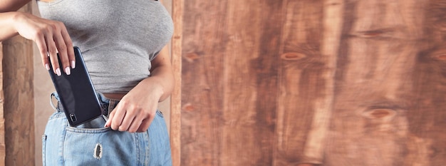 Donna che mette smartphone nella tasca dei jeans