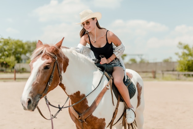 Donna che monta un cavallo in una campagna