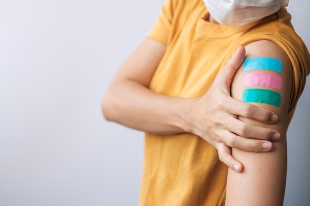 Donna che mostra intonaco dopo aver ricevuto il vaccino contro il covid 19. Vaccinazione, immunità di gregge, effetti collaterali, dose di richiamo, passaporto del vaccino e pandemia di Coronavirus