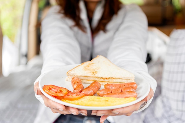 Donna che mostra la sua colazione sull'attività del campo