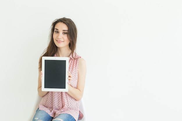 Donna che mostra lo schermo vuoto in tablet su sfondo bianco con spazio di copia