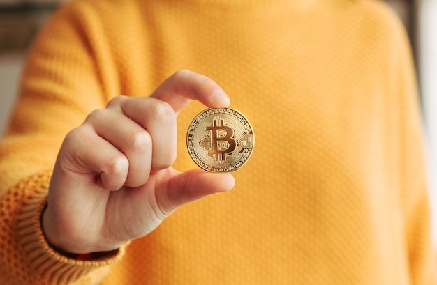 Donna che mostra un bitcoin in mano