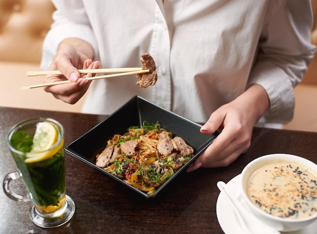 Donna che ordina un pasto in stile orientale nel ristorante.