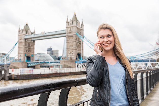 Donna che parla al telefono a Londra vicino a Tower Bridge