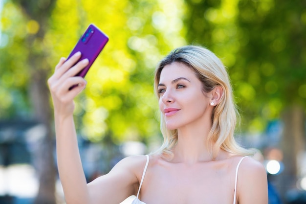 Donna che parla al telefono donna attraente utilizzando smart phone all'aperto all'aperto ritratto di donna graziosa