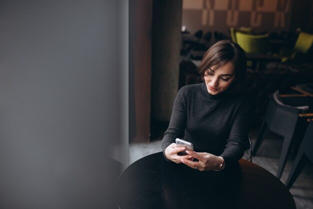 Donna che parla al telefono in un caffè