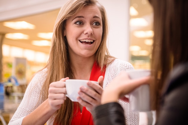 Donna che parla pur avendo caffè