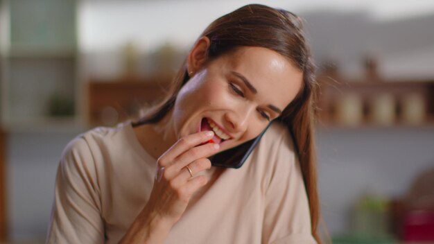 Donna che parla sullo smartphone a casa Casalinga che taglia verdure per insalata