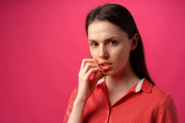 donna che pensa su sfondo rosa