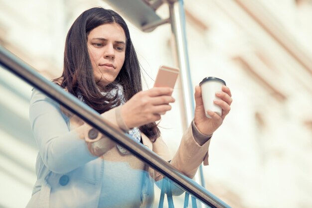 Donna che per mezzo del suo telefono astuto