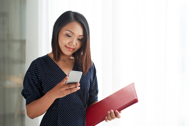 Donna che per mezzo del telefono cellulare