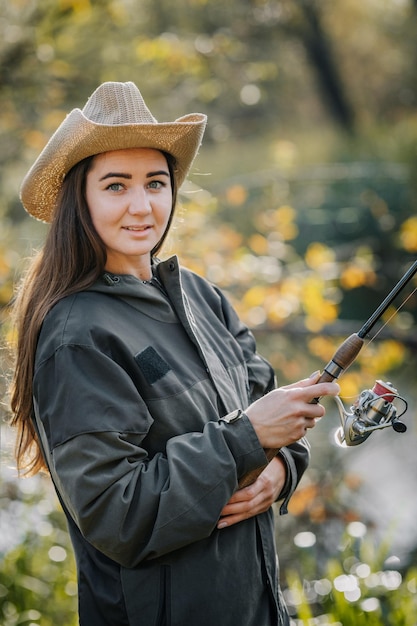 Donna che pesca sul fiume. Pescare con la canna da spinning.