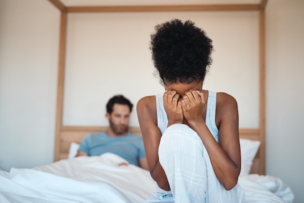 Donna che piange dopo aver litigato con il marito in camera da letto a casa Moglie triste dopo che la relazione del marito mente e tradisce a letto Coppia depressa che ha problemi di relazione e decide di divorziare