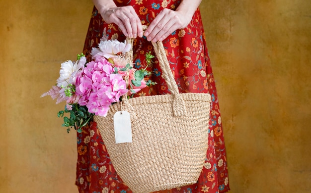 Donna che porta fiori in una borsa di vimini