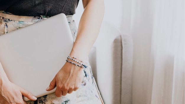 Donna che porta un laptop in una stanza