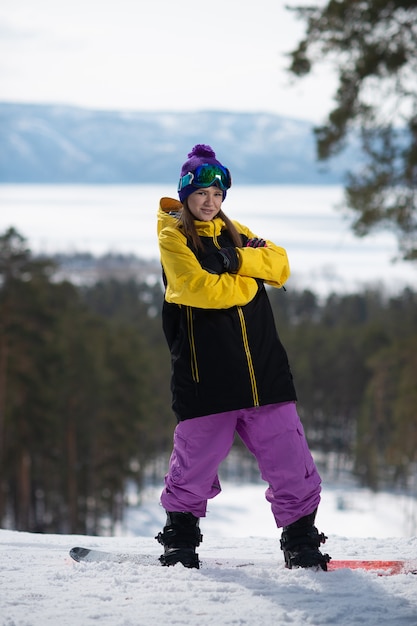 Donna che posa su uno snowboard