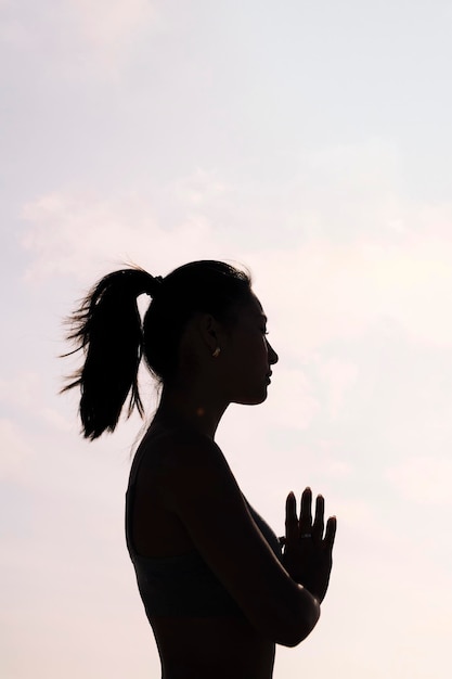 Donna che pratica lo yoga in posizione di preghiera