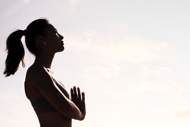 Donna che pratica lo yoga in posizione di preghiera