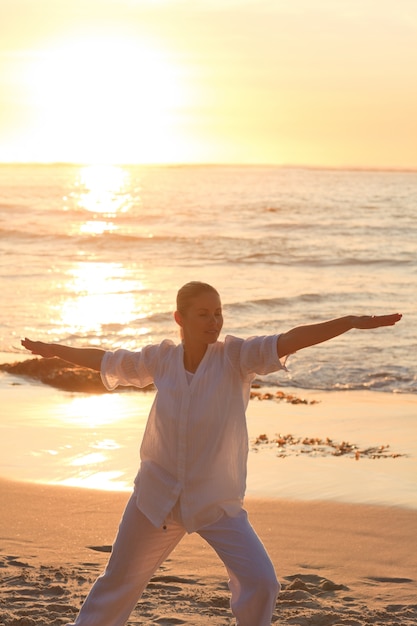 Donna che praticano yoga durante il tramonto