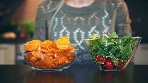 Donna che preferisce l'insalata alle patatine fritte