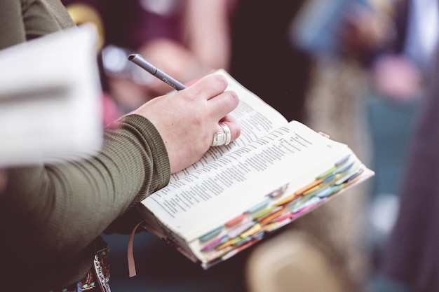 Donna che prende appunti nella Bibbia