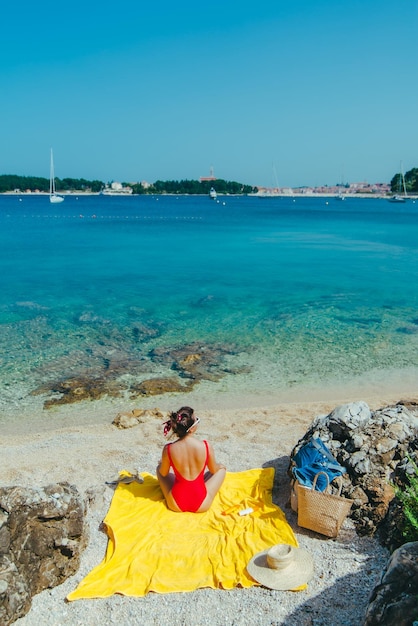 Donna che prende il sole sulla spiaggia del mare in una giornata di sole