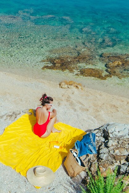 Donna che prende il sole sulla spiaggia del mare in una giornata di sole