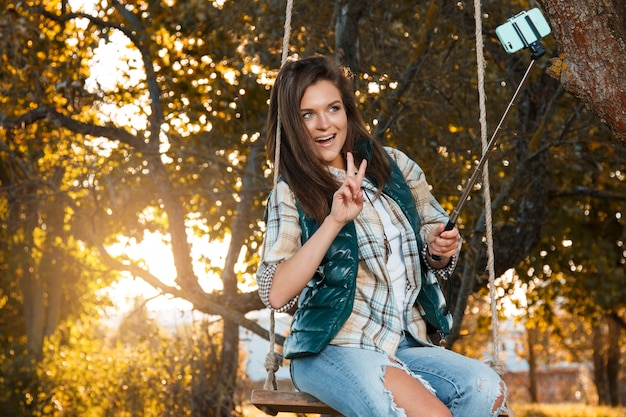 Donna che prende selfie nel parco di autunno